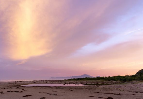 Stunning sunset view at Barra do Una beach, showcasing vibrant skies and serene coastline.