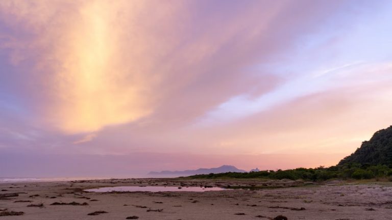 Stunning sunset view at Barra do Una beach, showcasing vibrant skies and serene coastline.