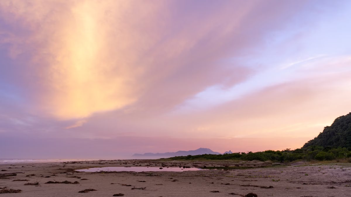 Stunning sunset view at Barra do Una beach, showcasing vibrant skies and serene coastline.